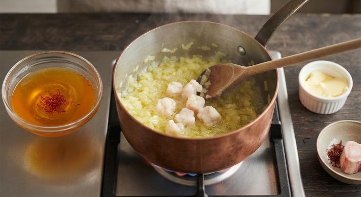 Sciogliete lo zafferano nel brodo di carne. Tritate la cipolla e ponetela in una casseruola insieme a metà dose di burro. Fatela appassire a fuoco lento e aggiungete il midollo di bue a pezzettini. Lasciate cuocere per due minuti circa.