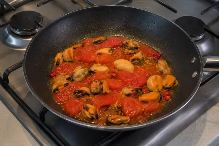 Aggiungete il sale ed unite il prezzemolo tritato. Mescolate bene e continuate la cottura per altri 5 minuti sempre a fiamma media. Infine, aggiungete le cozze sgusciate, mescolate bene per paio di minuti e poi spegnete il fuoco. Quando le penne sono cotte al dente, scolatele e mettetele nella padella con il sugo.