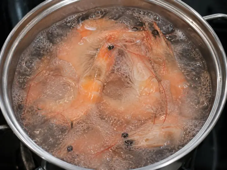 In un pentolino pieno di acqua versate i gamberi e portate ad ebollizione. Fate cuocere per circa 5 minuti, dopodichè scolateli e lasciateli raffreddare per qualche minuto. Pulite i gamberi eliminando la testa, le zampe e il guscio. Non eliminate invece la coda.