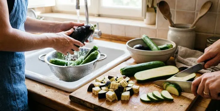 Lavate bene le melanzane e le zucchine. Tagliate le melanzane a pezzetti e le zucchine prima a metà per il senso della lunghezza e poi a fettine. Tritate la cipolla.