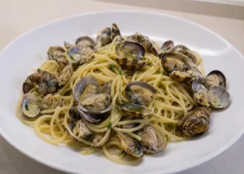 Piatto di spaghetti alle vongole servito in un piatto bianco con prezzemolo fresco