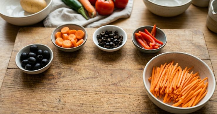 Passiamo ora alla decorazione: realizzate le orecchie tagliando a metà le rondelle di carota; tagliate a quadratini piccoli le olive nere per realizzare gli occhi; tagliate il peperone a striscioline per realizzare la bocca; infine, tagliate a julienne una carota per realizzare la coda.