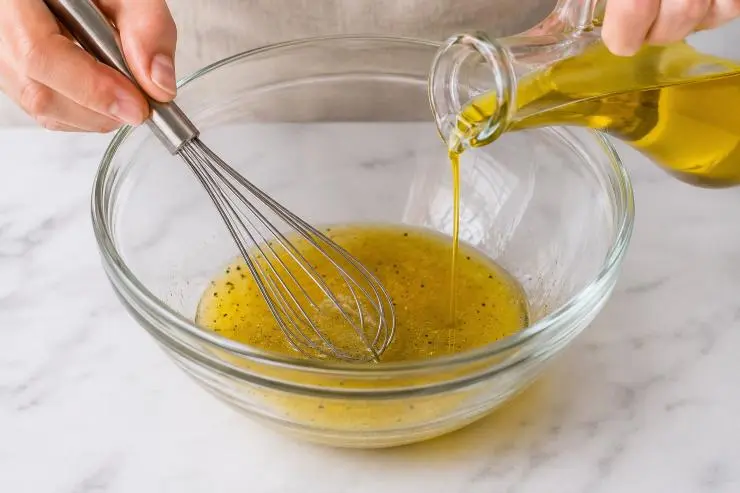 Aggiungete l’olio e sbattete con una frusta affinché tutti gli ingredienti vengano amalgamati in modo omogeneo. Se avete difficoltà potete utilizzare anche una frusta elettrica, l’importante è che il risultato finale sia un composto omogeneo i cui ingredienti non vadano a separarsi dopo poco tempo.