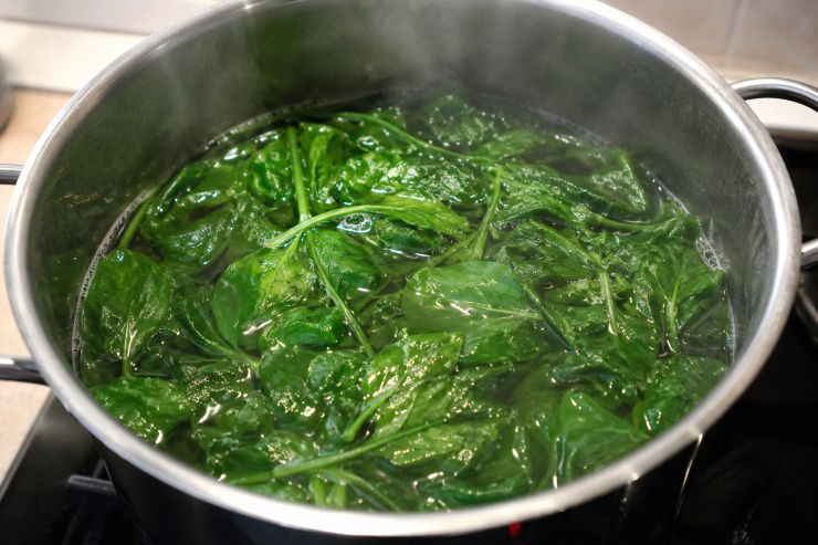 Nel frattempo pulite gli spinaci, lavateli bene e metteteli in una pentola riempita di acqua fino alla metà. Mettete sul fuoco, portate ad ebollizione e fate cuocere a fuoco lento fino a quando gli spinaci non sono completamente cotti. Trasferiteli in un colapasta e lasciateli raffreddare lì, in modo tale che venga eliminata tutta l’acqua in eccesso. Una volta freddi salateli e unite un filo di olio extravergine di oliva.