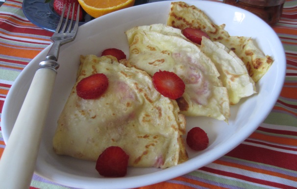 Servitele le crepes suzette con fragole ancora calde, decorate con le rimanenti fettine di fragole.