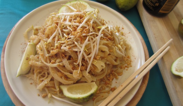 Disponete il Pad Thai nei piatti e decorate con qualche germoglio, delle fettime di lime e con gli arachidi tritati rimasti.