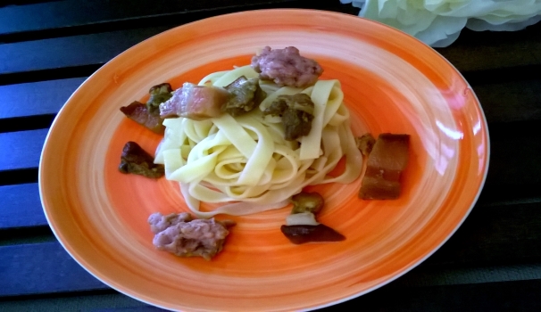 Le vostre tagliatelle con funghi porcini e salsiccia sono pronte per essere servite.