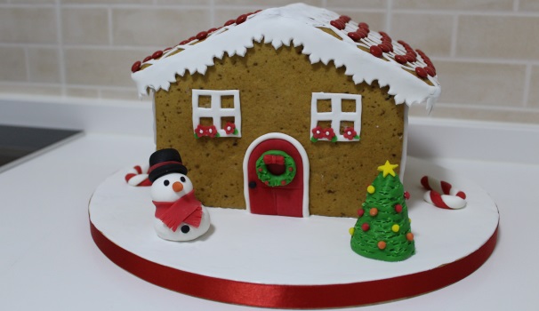 Per completare la vostra casetta di pan di zenzero, inserite altre decorazioni in pasta di zucchero. Io, ad esempio, ho scelto di creare un pupazzo di neve, un albero di Natale e dei bastoncini di zucchero.