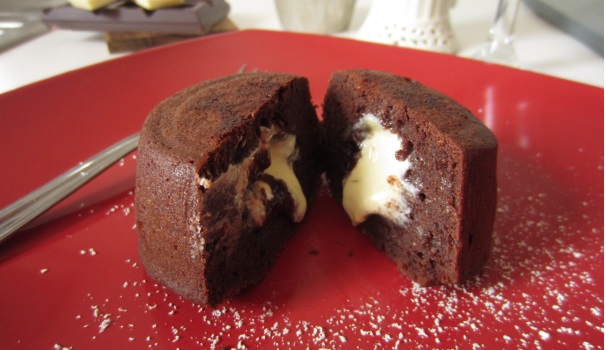 Servite la lava cake con cuore di cioccolato bianco appena sfornata.