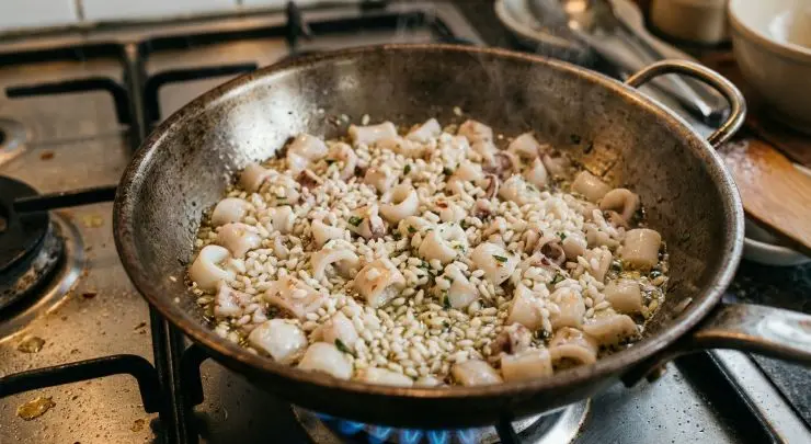 Aggiungete subito il riso, tostato precedentemente in un’altra padella, e mescolate bene. Cospargete tutto con il curry, salate e cuocete e per qualche minuto.