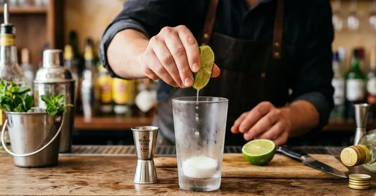 Prendete il tumbler precedentemente raffreddato in freezer. Versate lo zucchero in fondo al bicchiere. Tagliate il lime a metà e strizzate il succo di una metà sopra lo zucchero. Aggiungete 30 millilitri di rum.