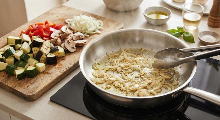 Iniziate riducendo le zucchine, la melanzana, il peperone e il porcino in pezzi non troppo piccoli. Affettate la cipolla e fatela rosolare in una padella con l’olio extravergine d’oliva.