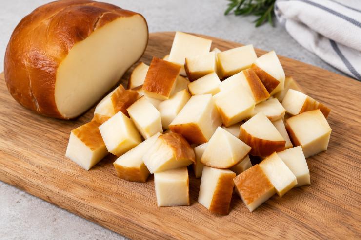 Aggiungete i pomodori al resto e tritate finemente, oppure se non volete ottenere una crema troppo liscia, lasciate pezzi più grossi visibili. Tagliate la scamorza affumicata a fette e poi a pezzi più piccoli.