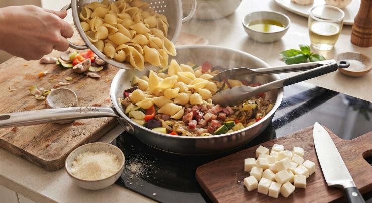 Riducete a dadini anche la mozzarella e tenetela da parte. Nel frattempo che le verdure terminano la cottura, lessate le conchiglie. Scolatele al dente e trasferitele nel tegame con le verdure e la pancetta. Aggiungete il parmigiano e una spolverata di pepe. Mescolate per amalgamare tutti gli ingredienti.