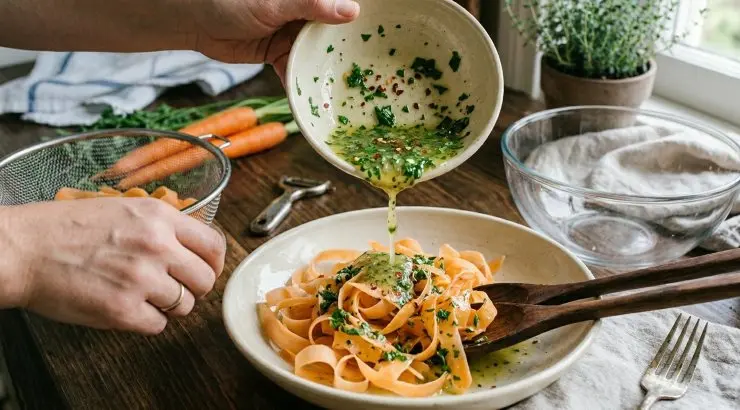 Unite un pizzico di peperoncino al condimento e rimescolate bene. Scolate le tagliatelle di carote delicatamente per non romperle. Unite il condimento e mescolate delicatamente. Servite subito.