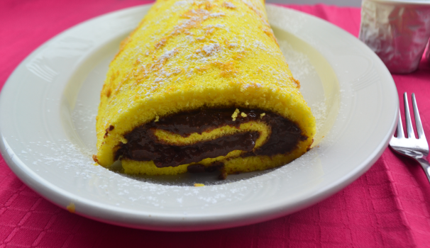 Spolverate la superficie con lo zucchero a velo e servite il rotolo di vaniglia ripieno di budino al cioccolato tagliandolo a fette.