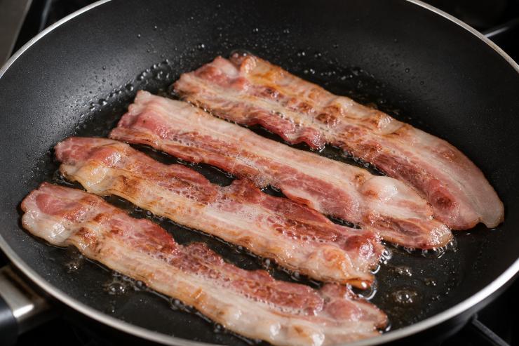 Scaldate una padella sulla fiamma alta, adagiatevi sul fondo rovente le fette di bacon e fatele tostare girandole da un lato e dall’altro. Una volta pronte sgocciolatele dal grasso formatosi in cottura e fate freddare su carta assorbente. Lavate bene la patata dolce e dividetela a metà, incidetela leggermente e conditela con un pizzico di sale e un filo di olio extravergine di oliva.