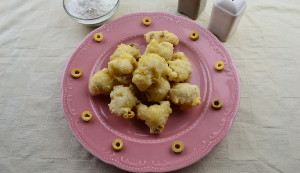 Dopo una spolverata di sale in superficie, le zeppole salate alle olive verdi sono pronte da gustare ancora belle calde.