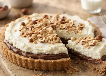 Crostata con ricotta e crema di nocciole tagliata su tagliere rustico in legno