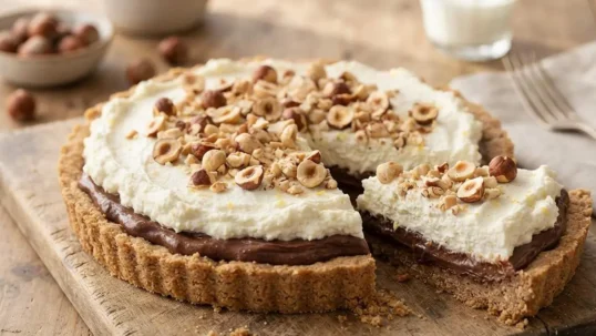 Crostata con ricotta e crema di nocciole tagliata su tagliere rustico in legno