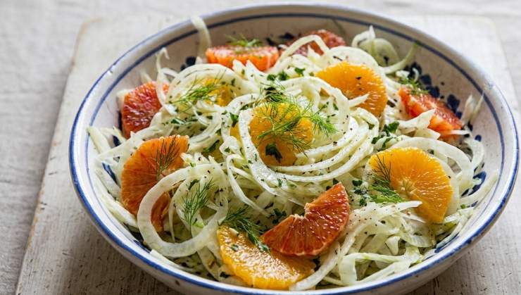 Pulite i finocchi, denocciolate le olive nere e pelate l’arancia a vivo quindi passate alla preparazione dell’insalata. Tagliate molto finemente i finocchi ed adagiateli in una ciotola, quindi separate gli spicchi d’arancia ed uniteli ai finocchi. Proseguite aggiungendo le olive intere denocciolate ed il cipollotto tagliato fine.