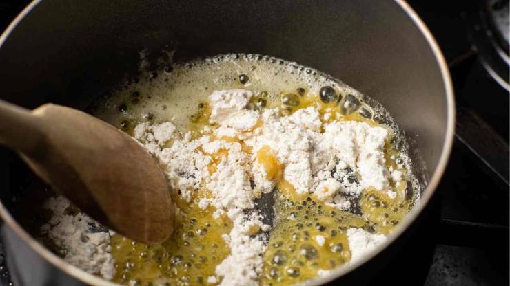 Intanto un altro pentolino mettete il burro e fatelo sciogliere dolcemente. Quando sarà completamente fuso, versate la farina tutta in una volta e mescolate energicamente con una frusta a mano per evitare grumi. Continuate a mescolare finché otterrete un composto dorato e omogeneo: questo è il roux, la base perfetta della vostra besciamella.