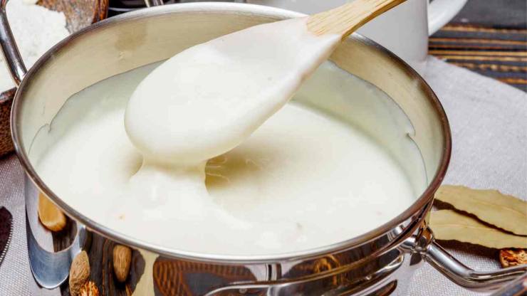 Versate poco latte caldo nel roux e mescolate velocemente per stemperarlo, quindi aggiungete poi tutto il resto del latte a filo, continuando ad amalgamare per evitare la formazione di grumi e mantenere una consistenza liscia. Continuate la cottura a fuoco dolce per 5-6 minuti sempre mescolando, finché la besciamella si addenserà leggermente. A questo punto è pronta: cremosa, vellutata e profumata di noce moscata.