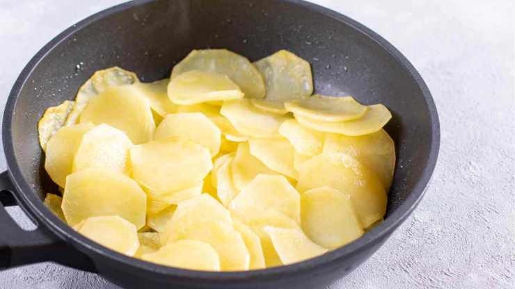 In una brocca sciogliete 10 grammi di sale in un litro d’acqua: vi servirà per regolare la sapidità della tiella. E’ il momento di comporre il piatto: ungete il fondo della teglia con olio extravergine d’oliva, poi fate un primo strato con cipolla, aglio, prezzemolo e pomodorini. Aggiungete sopra le fette di patate, cercando di disporle in modo uniforme e condite con un filo d’olio extra vergine d’oliva. In una brocca sciogliete 10 grammi di sale in un litro d’acqua: vi servirà per regolare la sapidità della tiella. E’ il momento di comporre il piatto: ungete il fondo della teglia con olio extravergine d’oliva, poi fate un primo strato con cipolla, aglio, prezzemolo e pomodorini. Aggiungete sopra le fette di patate, cercando di disporle in modo uniforme e condite con un filo d’olio extra vergine d’oliva.
