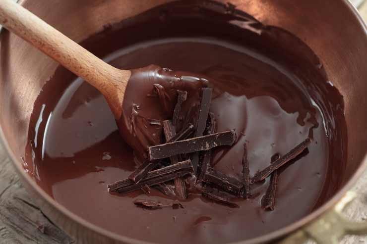 Iniziate la ricetta tritando grossolanamente il cioccolato fondente e mettendolo in una ciotola insieme al burro. Sciogliete a bagnomaria, mescolando di tanto in tanto fino ad ottenere un composto liscio e cremoso: aggiungete il cacao amaro, mescolate bene e lasciate intiepidire. In una ciotola a parte sgusciate le uova ed unite lo zucchero: montate finché il composto diventa chiaro e spumoso. Iniziate la ricetta tritando grossolanamente il cioccolato fondente e mettendolo in una ciotola insieme al burro. Sciogliete a bagnomaria, mescolando di tanto in tanto fino ad ottenere un composto liscio e cremoso: aggiungete il cacao amaro, mescolate bene e lasciate intiepidire. In una ciotola a parte sgusciate le uova ed unite lo zucchero: montate finché il composto diventa chiaro e spumoso.