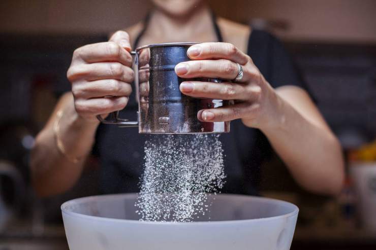 Iniziate prendendo un pentolino e setacciate l’amido di mais e lo zucchero a velo: versate la panna a filo e mescolate continuamente con una frusta a mano fino a che il composto risulterà liscio. Se dovessero formarsi dei grumi, filtrate tutto con un colino. Iniziate prendendo un pentolino e setacciate l’amido di mais e lo zucchero a velo: versate la panna a filo e mescolate continuamente con una frusta a mano fino a che il composto risulterà liscio. Se dovessero formarsi dei grumi, filtrate tutto con un colino.