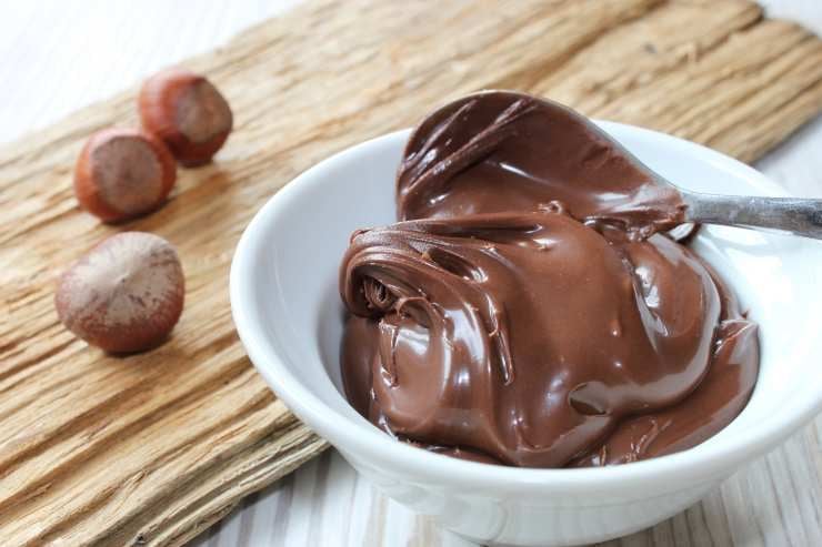 Trascorso il tempo necessario riprendete lo stampo e fate un secondo strato: sciogliete altri 100 grammi di cioccolato fondente e spennellatelo nuovamente sul primo strato, quindi rimettete in frigo per altri 30 minuti. Fatto ciò preparate il ripieno: tritate finemente il cioccolato al latte e scioglietelo a bagnomaria. Unite la crema di nocciole e mescolate fino ad ottenere una crema omogenea, quindi aggiungete anche le nocciole tostate ed amalgamate bene. Trascorso il tempo necessario riprendete lo stampo e fate un secondo strato: sciogliete altri 100 grammi di cioccolato fondente e spennellatelo nuovamente sul primo strato, quindi rimettete in frigo per altri 30 minuti. Fatto ciò preparate il ripieno: tritate finemente il cioccolato al latte e scioglietelo a bagnomaria. Unite la crema di nocciole e mescolate fino ad ottenere una crema omogenea, quindi aggiungete anche le nocciole tostate ed amalgamate bene.