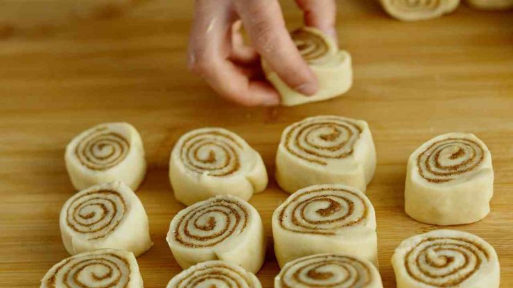 Coprite e lasciate lievitare fino al raddoppio: ci vorrà circa un’ora e mezza. Intanto preparate il ripieno mescolando burro morbido, zucchero di canna e cannella in modo da realizzare una crema omogenea.Trascorso il tempo necessario, stendete l’impasto in un rettangolo di circa 30×20 centimetri e spalmate il ripieno su tutta la superficie lasciando pochi millimetri dai bordi.