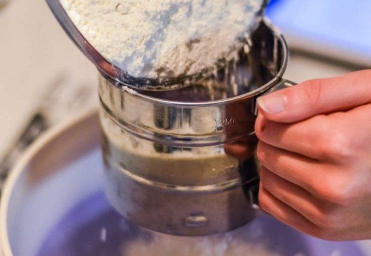 Unite ora la farina setacciata con il lievito ed il pizzico di sale, alternando con il latte tiepido mescolato con l’estratto di vaniglia e sempre poco alla volta e senza smettere di mescolare con le fruste oppure il gancio impastatore della planetaria, fino ad ottenere un impasto morbido ed omogeneo. Incorporate ora anche l’uvetta, i canditi se vi piacciono e le scorze degli agrumi, mescolando delicatamente questa volta con una spatola.