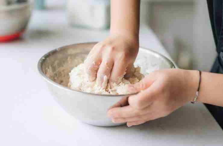 Quando l’impasto avrà raggiunto una certa consistenza, proseguite con le mani ed unite anche il sale e due cucchiai di olio extra vergine d’oliva: lavorate energicamente fino ad ottenere un panetto liscio, morbido e non appiccicoso. Trasferite l’impasto su una spianatoia infarinata e, con l’aiuto di un mattarello, stendete una sfoglia di circa 5/6 millimetri di spessore. Usando un coppapasta o un bicchiere grande ricavate tanti cerchi e distribuite al centro di ognuno un po’ di passata di pomodoro, pezzetti di mozzarella e prosciutto cotto.