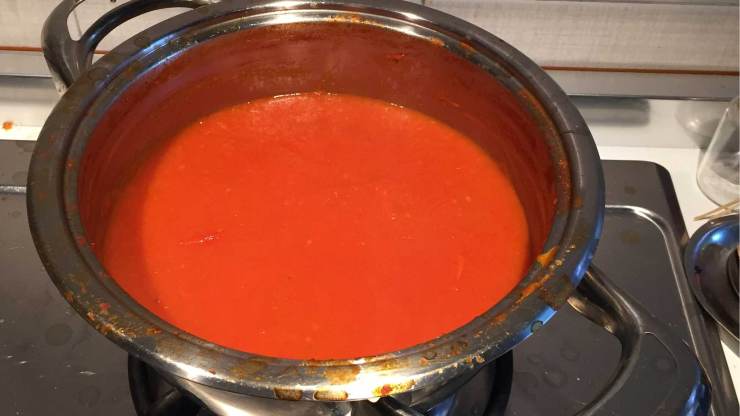Intanto preparate il sugo: versate la cipolla affettata finemente in una casseruola capiente, aggiungete l’olio extra vergine d’oliva e fate soffriggere. Unite anche la passata di pomodoro, regolate di sale e coprite con un coperchio lasciandolo leggermente aperto per far uscire il vapore. Tenete la fiamma al minimo e cuocete una decina di minuti: il sugo dovrà addensarsi leggermente senza restringersi del tutto.