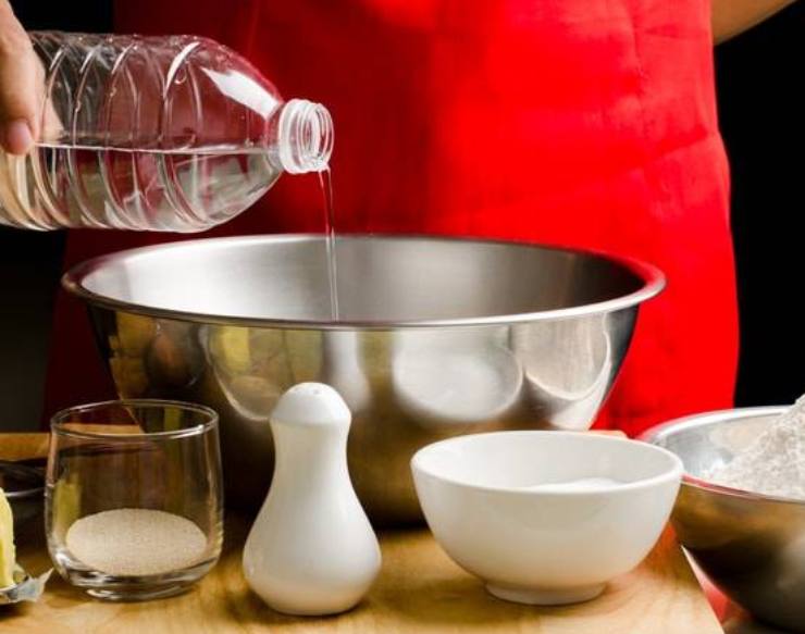 Sciogliete il lievito nell’acqua tiepida, poi versate la farina in una ciotola ampia ed unite il sale. Aggiungete l’acqua poco alla volta, mescolando con una mano o con un cucchiaio di legno fino a raggiungere una certa consistenza.Lavorate l’impasto energicamente per almeno 10 minuti finché diventa morbido, liscio e molto appiccicoso: non preoccupatevi quindi se vi dovesse sembrare troppo molle, è la sua consistenza ottimale.