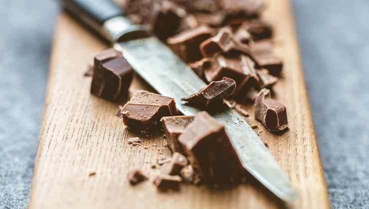 Tritate grossolanamente la tavoletta di cioccolato fondente e distribuitelo sulla superficie. Trasferite in forno e cuocete in modalità statica a 180 gradi per circa 45 minuti. Fate la prova stecchino: deve uscire leggermente umido, non completamente asciutto. Fatto ciò spegnete e fate raffreddare completamente prima di sformarla, poi servitela subito!