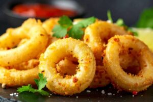 calamari fritti dorati su tavolo nero
