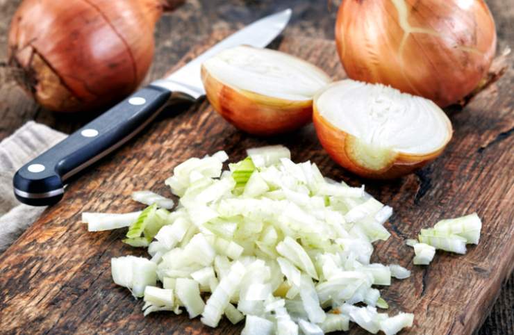 Iniziamo dalla pulizia delle cipolle: sbucciamole e tagliamole a pezzetti o fettine. Laviamo e sminuzziamo il sedano, conservando le foglie. Peliamo e tritiamo la carota. Prendiamo le foglie di sedano e uniamole a quelle di prezzemolo e alla foglia di alloro;&nbsp;