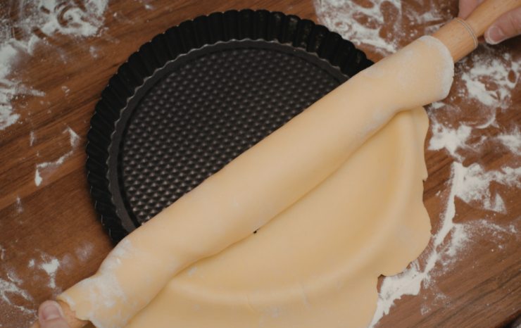 Riprendiamo il panetto e stendiamo con un matterello, poi adagiamo in uno stampo da forno dai bordi alti che avremo imburrato o foderato. Lavoriamo anche i bordi e tagliamo via l’eccesso;