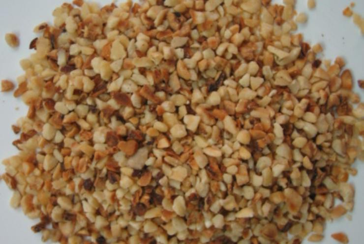 Intanto tritate grossolanamente le nocciole: non devono diventare farina, ma devono sentirsi un po’ i pezzettini che rendono il croccante più bello e rustico. Quando il caramello ha raggiunto un bel colore ambrato, spegnete il fuoco ed aggiungete subito le nocciole tritate. Mescolate bene finché sono completamente avvolte dal caramello e versate il composto ancora caldo su un piano rivestito di carta forno.