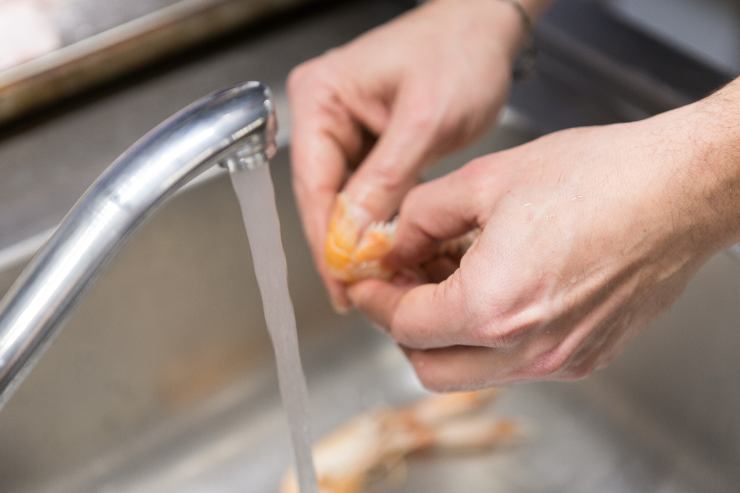 Nel frattempo, pulisci i gamberi eliminando la testa, l’intestino ed il carapace. Se sono surgelati, lasciali prima scongelare gradualmente a temperatura ambiente. Sciacquali sotto l’acqua corrente e tamponali con un pezzo di carta assorbente.