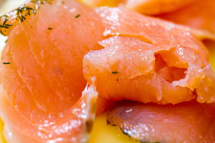 Taglia il salmone affumicato a listarelle e poi prendi quindi una pirofila rettangolare e cospargi la base con una manciata di pangrattato. Aggiungi metà composto di patate e livella bene con una spatola, creando come un bordino sui lati. Metti al centro il salmone, la scamorza tagliata a fettine e poi cospargi la superficie con il parmigiano grattugiato.