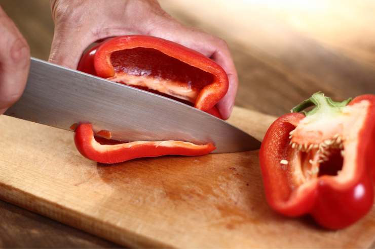 Lava i peperoni ed elimina il picciolo, i semi e i filamenti interni. Dopodiché, tagliali a listarelle e metti a scaldare una padella sul fuoco. Cuoci i peperoni a fiamma medio-bassa con il coperchio finché non si saranno leggermente ammorbiditi e poi regola di sale e di pepe. Una volta pronti, tienili da parte.