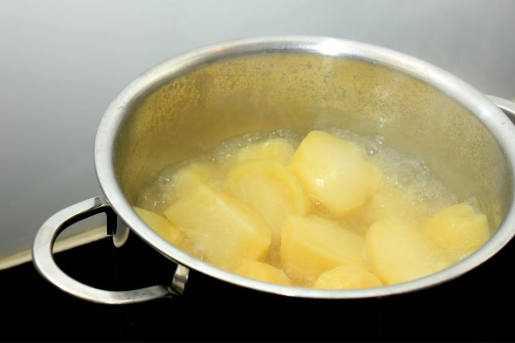 Dopodiché, pela le patate, tagliale a tocchetti e mettile a bollire nella stessa pentola. Quando saranno pronte, scolale e frullale con un mini pimer, aggiungendo un goccio d’acqua se serve. Trasferisci il composto in una scodella ed aggiungi il formaggio fresco spalmabile, sale e pepe.