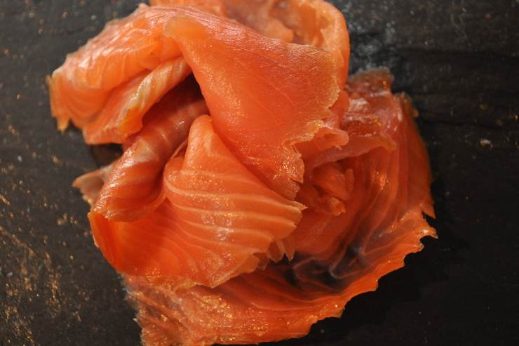 Copri l’interno dello stampo foderato con le fette di salmone affumicato, andando a ricoprire bene anche i bordi. Aggiungi la farcia precedentemente realizzata, livella la superficie con l’aiuto di una spatola in silicone o il dorso di un cucchiaio e chiudi tutto con altre fette di salmone affumicato.