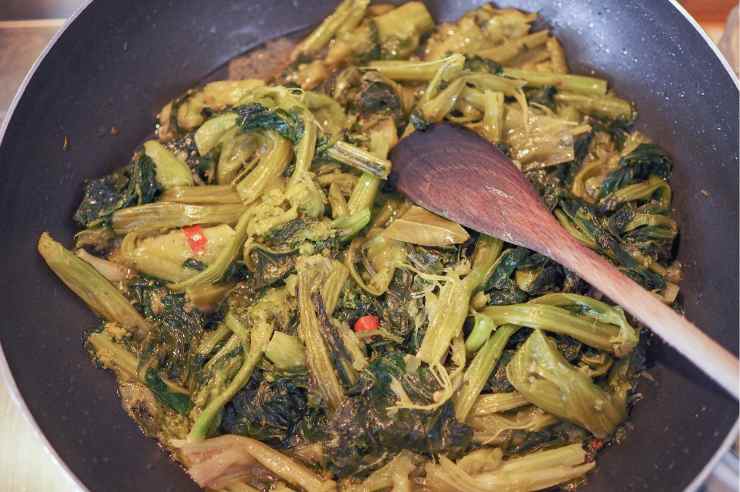 Trascorso il tempo necessario, scola le cime di rapa e trasferiscile nella padella in cui hai fritto la mollica, aggiungendo un giro d’olio extravergine d’oliva, uno spicchio d’aglio, del peperoncino e qualche filetto d’acciuga. Nella pentola con l’acqua cuoci invece le orecchiette.