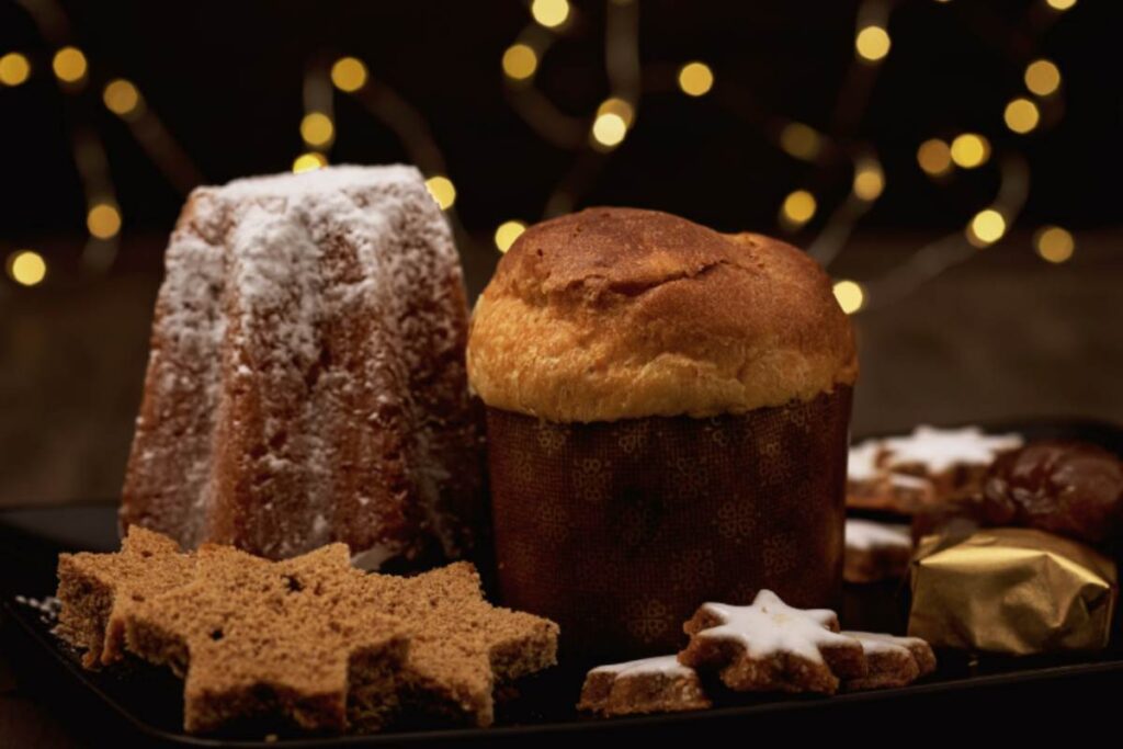 panettone e pandoro su tavolo con biscotti di natale