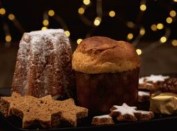 panettone e pandoro su tavolo con biscotti di natale