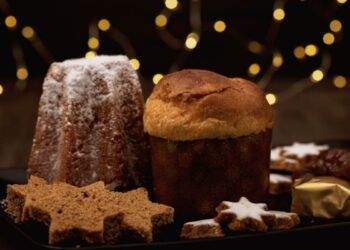 panettone e pandoro su tavolo con biscotti di natale
